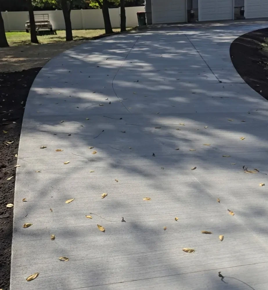 Concrete driveway flanked by shaded leaves in an Owatonna neighborhood