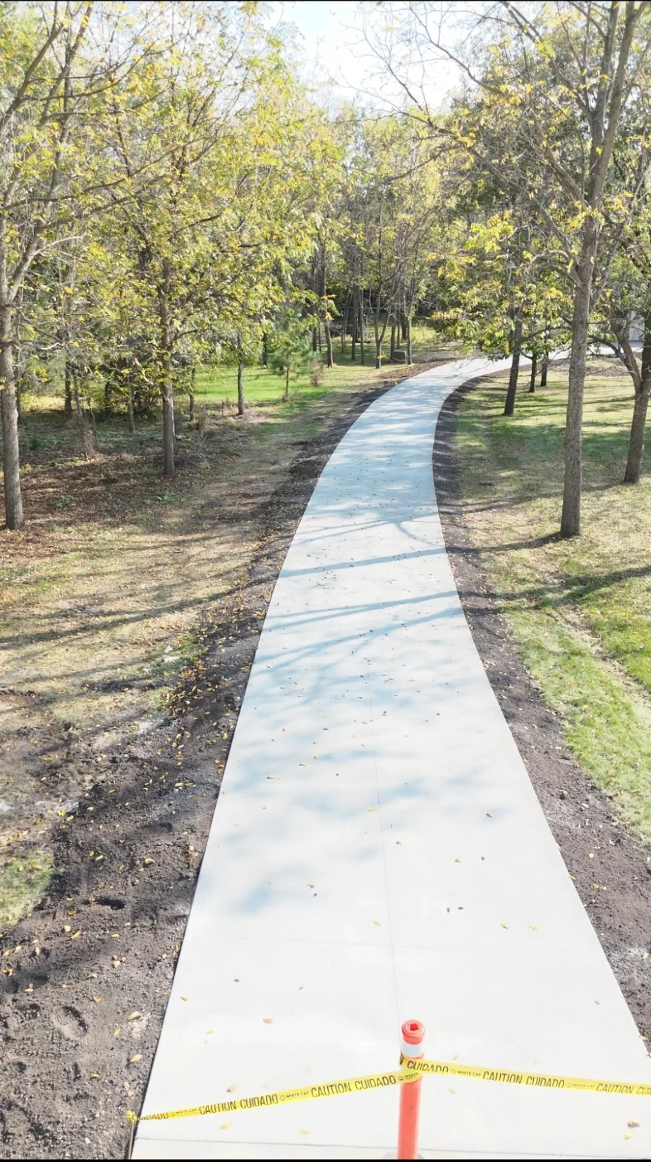 Concrete walking path through fall trees in a southern Minnesota park