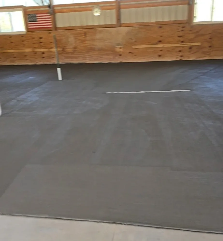 Pole barn interior with American flag and fresh concrete slab